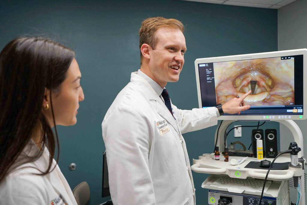 photo of Rohlfing and SLP reviewing laryngoscopy findings