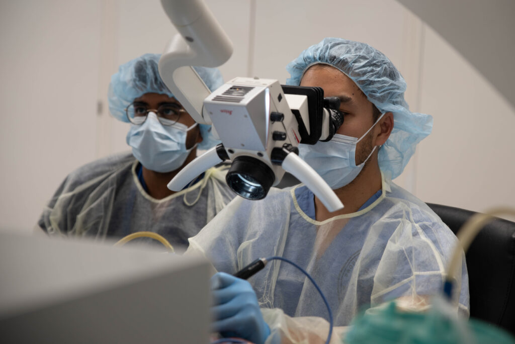 photo of residents at surgical microscope